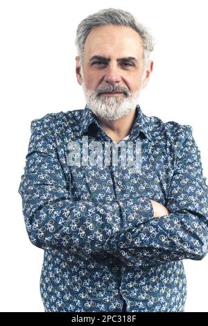 Vertikales Studiofoto eines älteren, bärtigen, grauhaarigen Mannes in einem blau gemusterten Button-Up-Shirt. Eine ernste Haltung. Verschränkte Arme. Isoliert auf weißem Hintergrund. Hochwertige Fotos. Stockfoto