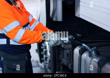 Mann betankt Diesel auf einem großen Lkw, Lkw-Fahrer betankt, globale Erwärmung, Verschmutzung, fossile Brennstoffe, Stockfoto