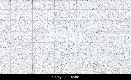 Wand oder Boden aus weißen Terrazzo-Fliesen mit schwarzen Flecken, Draufsicht oder Vorderansicht. Abstrakter texturierter Vollformathintergrund. Speicherplatz kopieren. Stockfoto