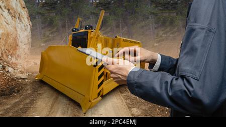 Ingenieur Programme autonomen Bulldozer mit digitalen Tablet Stockfoto