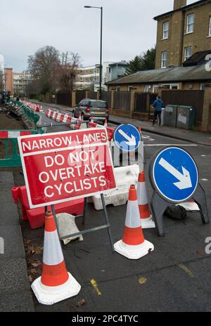 Schmale Spur Radfahrer nicht überholen Schild an Straßenbauarbeiten in teddington, middlesex, england, neben Pegeln und Wegweisern Stockfoto