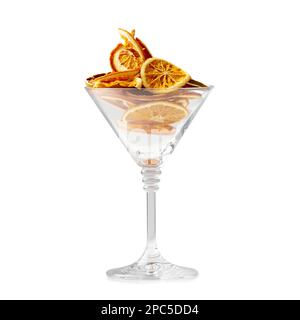 Trockene orangefarbene Chips isoliert. Orangefarbene Chips in einem Glas martini Glas auf weißem Hintergrund. Richtige Ernährung. Fruchtstückchen. Trockenscheiben von Zitrusfrüchten. Stockfoto