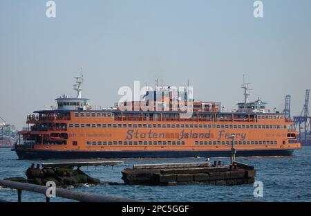 Eine große orangefarbene Staten Island-Fähre, die in New York, USA, in der Nähe eines Wassers vor Anker liegt. Stockfoto
