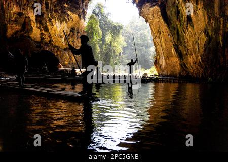 Touristen in Silhouette fuhren auf Bambusflocken innerhalb des Tunnels in den Höhlen von Tham Nam Lod, Provinz Mae Hong Son, Thailand. Stockfoto