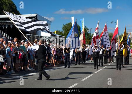 Quimper, Frankreich - Juli 24 2022: Fahnenträger präsentieren die verschiedenen Banner der bretonischen Länder während des Festivals von Cornouaille. Stockfoto