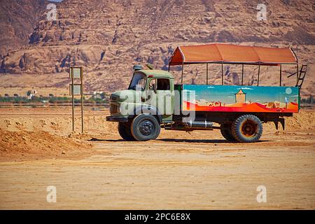 Ein alter und rostiger Truck in verschiedenen Farben, der in der Wüste geparkt hat Stockfoto