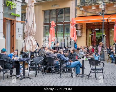 Bukarest, Rumänien - 2023. März: Urbane Szene mit Menschen, die an Tischen sitzen und einen Drink in der Altstadt von Bukarest genießen Stockfoto