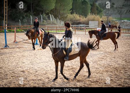 Männer-Frauen-Wettkämpfe im Reitsport. Mutige Männer und Frauen, die über Sprünge reiten. Männer und Frauen zeigen ihre Reitkünste. Stockfoto