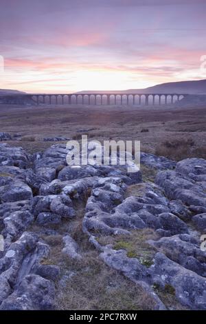 Blick auf Kalksteinklippen und Ribblehead Viaduct bei Sonnenuntergang, Ribblehead, Ribblesdale, Yorkshire Dales N. P. North Yorkshire, England, Großbritannien Stockfoto