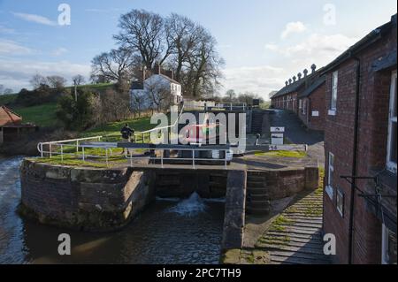 Narrowboat durch die Kanalschleuse, Bunbury Locks, Shropshire Union Canal, Bunbury, Cheshire, England, Vereinigtes Königreich Stockfoto