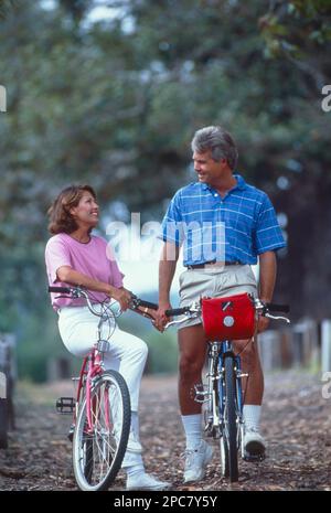 Ein weißes Paar mittleren Alters, das eine Pause machte, während es Fahrrad fuhr, um zu reden Stockfoto
