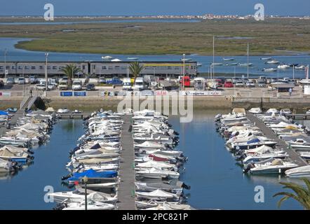 Blick über den Yachthafen mit vorbeifahrendem Zug, mit Flussmündung und Salzmarsch im Hintergrund, Faro, Algarve, Portugal Stockfoto