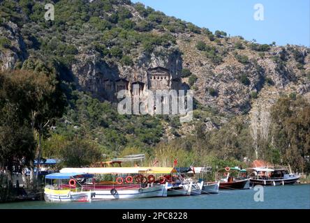 Blick auf Touristenboote auf dem Fluss und lykische Felsgräber (ca. 400 v. Chr.), die in den Felsen gehauen wurden, Fluss Dalyan, Provinz Mugla, Türkei Stockfoto