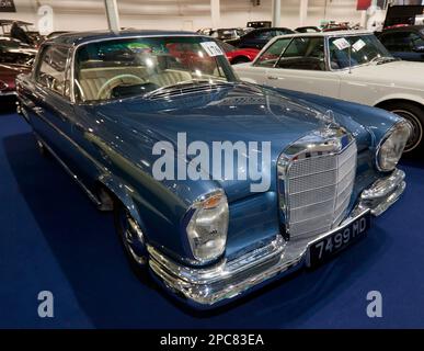 Dreiviertel Vorderansicht eines Blue, 1962, Mercedes-Benz 220SE, Teil der London Classic Car Auction 2023 bei Olympia, London Stockfoto