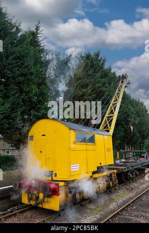 Funktionierender, Dampfbetriebener Eisenbahnkran. DS58 10 Tonnen Lift an der Watercress Line in Hampshire. Rauch, der aus dem Trichter strömt. Stockfoto