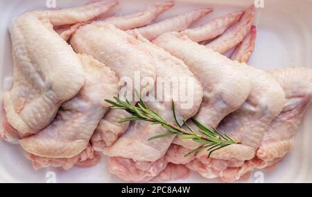 Rohe Hähnchenflügel, isoliert im Hintergrund mit voller Schärfentiefe. Draufsicht. Flach verlegt. Stockfoto