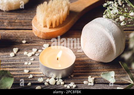 Spa-Komposition mit Badebombe, Kerze und getrockneten Blumen. Stockfoto