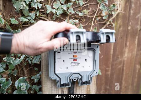 Hausbesitzer mit vollständig geöffneter Doppelsteckdose und kombiniertem Schutzschalter. Beachten Sie den Gummikoffer, der eine wetterfeste Abdichtung bietet. Stockfoto