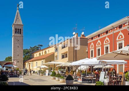 Glockenturm / Glockenturm und Terrassen von Restaurants im historischen Stadtzentrum von Novigrad, Istrien County, Kroatien Stockfoto