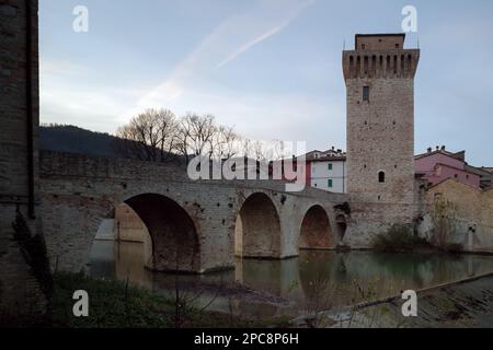 Alte römische Steinbrücke und mittelalterlicher Turm über dem Fluss Metauro in Italien, in der Stadt Fermignano, einem kleinen Dorf in der Nähe von Urbino Stockfoto