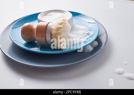 Festes Spülmittel, mit Schaum bedeckt. Kein verschwenderischer Lebensstil. Geschirrspülmaschine mit schaumiger Küchenreinigung Sisal-Bambus-Rundspülbürste Stockfoto