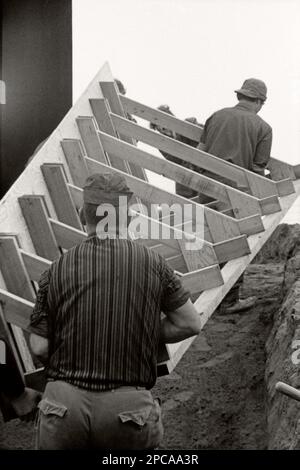 Bauarbeiter auf einem Außengelände im Jahr 1971. Retro- oder Vintage-Schwarzweißfotos Stockfoto