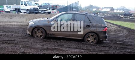 Itterbeck, Deutschland, März 12 2023, Ein total dreckiger Mercedes-SUV, der auf einer Off-Road-Strecke durch den Schlamm fährt. Es ist ein Mercedes-Benz W 166 Stockfoto