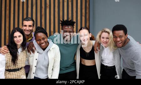 Das Business-Team besteht aus jungen Geschäftsleuten, die Seite an Seite stehen Stockfoto