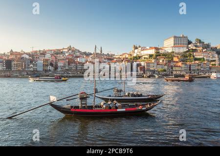 Rabelo-Boote am Douro-Fluss, mit Tourbooten und der Stadt Porto im Hintergrund, an einem Sommernachmittag. Stockfoto