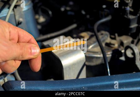 Der Fahrer prüft den Ölstand im Motor. Stockfoto