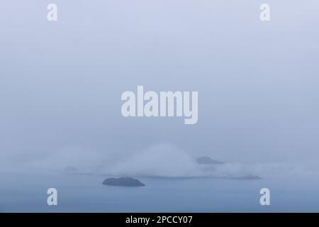 Kleine Inseln im wunderschönen Lago Buenos Aires/Lago General Carrera in der Nähe von Puerto Rio Tranquilo, umgeben von dickem Nebel Stockfoto