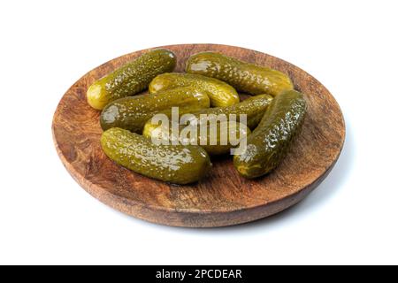 Eingelegte Gurken auf Holzplatte isoliert. Fermentierte Lebensmittel, mariniertes Gemüse, Gewürzgurken, eingelegte Gurken auf weißem Hintergrund Stockfoto