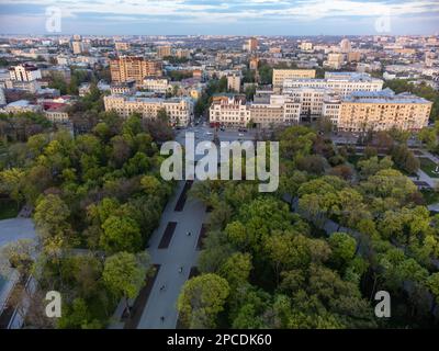 Atemberaubende grüne Quelle Shevchenko City Garden mit Taras Shevchenko Monument bei Sonnenuntergang. Touristenattraktion im zentralen Stadtpark, Charkiv, Ukraine Stockfoto