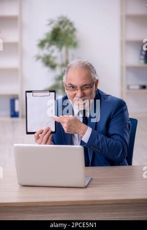 Der alte Boss, der im Büro arbeitet Stockfoto