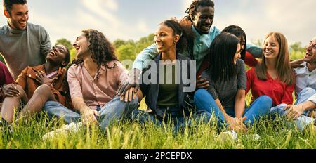 Eine fröhliche und vielfältige Gruppe von Freunden, darunter Studenten und internationale Reisende, nimmt an Outdoor-Aktivitäten und Entspannung in einer pulsierenden Stadt Teil Stockfoto