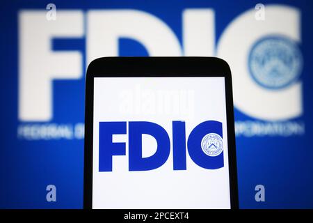 Ukraine. 13. März 2023. In dieser Abbildung ist das FDIC-Logo (Federal Deposit Insurance Corporation) auf einem Smartphone und im Hintergrund zu sehen. (Kreditbild: © Pavlo Gonchar/SOPA Images via ZUMA Press Wire) NUR REDAKTIONELLE VERWENDUNG! Nicht für den kommerziellen GEBRAUCH! Stockfoto