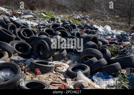 Erstaunliche Umweltverschmutzung in Ungarn. In der Nähe einer Stadt liegt eine Menge Müll neben einer unbefestigten Straße an der Grenze. Umweltverschmutzung. Illegales Dumping. Stockfoto