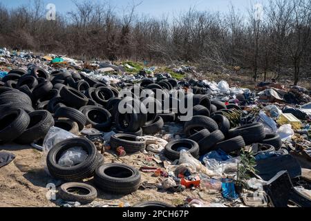 Erstaunliche Umweltverschmutzung in Ungarn. In der Nähe einer Stadt liegt eine Menge Müll neben einer unbefestigten Straße an der Grenze. Umweltverschmutzung. Illegales Dumping. Stockfoto