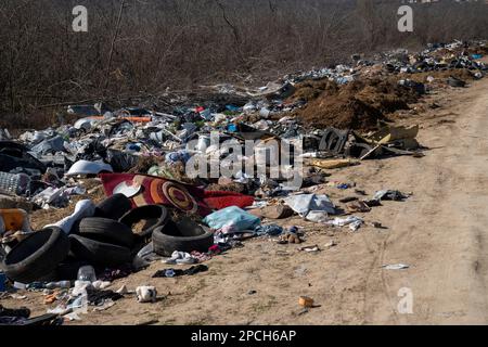 Erstaunliche Umweltverschmutzung in Ungarn. In der Nähe einer Stadt liegt eine Menge Müll neben einer unbefestigten Straße an der Grenze. Umweltverschmutzung. Illegales Dumping. Stockfoto