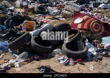 Erstaunliche Umweltverschmutzung in Ungarn. In der Nähe einer Stadt liegt eine Menge Müll neben einer unbefestigten Straße an der Grenze. Umweltverschmutzung. Illegales Dumping. Stockfoto