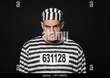 Gefangener in gestreifter Uniform auf schwarzem Hintergrund Stockfoto