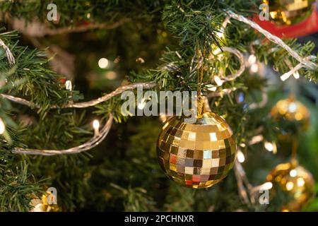 Nahaufnahme der glitzernden Kugeln auf dem Weihnachtsbaum mit LED-Lichtern. Stockfoto