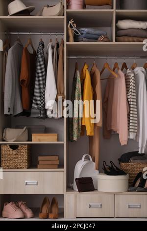 Kleiderschrank mit verschiedenen stilvollen Kleidungsstücken, Accessoires und Schuhen Stockfoto