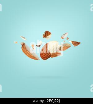 Leckere Mandelstücke auf türkisfarbenem Hintergrund Stockfoto