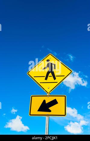 Gelbes Warnschild, Menschen mit blauem Himmelshintergrund in Sitka, Alaska, USA das Alexander-Archipel ist eine 300 km lange Inselgruppe im Norden Stockfoto