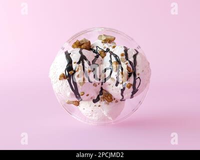 Eiskrem-Bälle von oben, weiß mit Schokoladensoße und Walnüssen in der Schüssel auf pinkfarbenem Hintergrund. Kreative Eisschale. Makro-Nahaufnahme Stockfoto