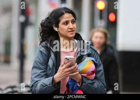 London, Großbritannien. 13. März 2023. Eine Frau hält ihr Mobiltelefon, während sie in London auf der Straße unterwegs ist. Kredit: SOPA Images Limited/Alamy Live News Stockfoto