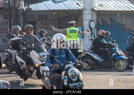 Canggu, Bali, Indonesien - 14. März 2023: Polizeibeamter, der den Verkehr auf den Straßen von Canggu, Bali, Indonesien leitet. Stockfoto