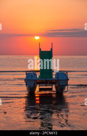 Tretboot am Strand bei herrlichem Sonnenaufgang Stockfoto