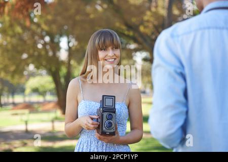 Liebe und Leidenschaft für Fotografie teilen. Ein junges Paar, das draußen Fotos mit alten Kameras macht. Stockfoto